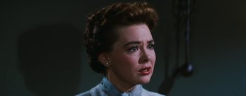 Movie still from “Bigger Than Life” (1956), directed by Nicholas Ray – A woman in a blue dress looking to her left; Close Up shot, Over the shoulder angle