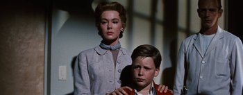 Movie still from “Bigger Than Life” (1956), directed by Nicholas Ray – A woman and a young boy standing next to each other; Medium shot, Low angle