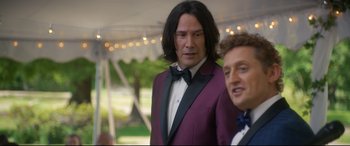 Movie still from “Bill & Ted Face the Music” (2020), directed by Dean Parisot – A man in a purple suit standing next to another man in a purple suit; Medium shot, Over the shoulder angle
