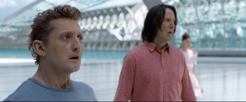 Movie still from “Bill & Ted Face the Music” (2020), directed by Dean Parisot – Two people standing next to each other near a building; Close Up shot, Over the shoulder angle