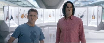 Movie still from “Bill & Ted Face the Music” (2020), directed by Dean Parisot – Two men standing next to each other in a room; Medium shot, Low angle
