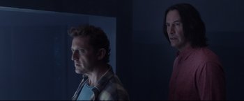 Movie still from “Bill & Ted Face the Music” (2020), directed by Dean Parisot – Two men standing in a dark room looking at each other; Medium shot, Low angle