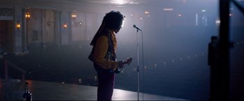 Movie still from “Bill & Ted Face the Music” (2020), directed by Dean Parisot – A person standing in front of a microphone and holding a guitar; Wide shot, Low angle