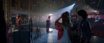 Movie still from “Bill & Ted Face the Music” (2020), directed by Dean Parisot – A woman is taking a picture of a man in a kimono; Wide shot, Over the shoulder angle