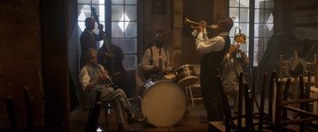Movie still from “Bill & Ted Face the Music” (2020), directed by Dean Parisot – A group of people playing musical instruments in a room; Extreme Wide shot, Low angle