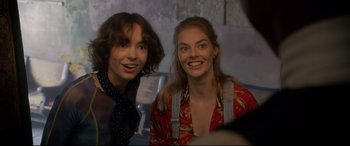 Movie still from “Bill & Ted Face the Music” (2020), directed by Dean Parisot – Two young people smile for the camera; Close Up shot, Over the shoulder angle