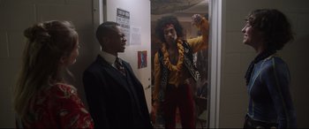 Movie still from “Bill & Ted Face the Music” (2020), directed by Dean Parisot – A man in a suit standing next to another man in a yellow shirt; Medium shot, Over the shoulder angle