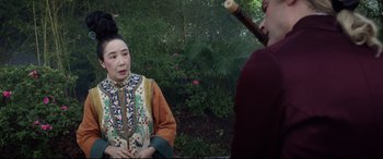 Movie still from “Bill & Ted Face the Music” (2020), directed by Dean Parisot – A woman in a kimono is holding a pipe in her mouth; Medium shot, Over the shoulder angle
