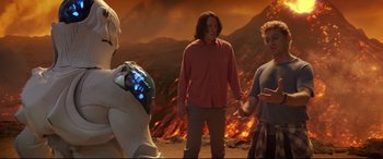 Movie still from “Bill & Ted Face the Music” (2020), directed by Dean Parisot – A group of people standing in front of a burning field; Medium shot, Over the shoulder angle