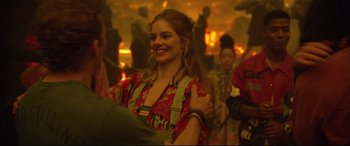 Movie still from “Bill & Ted Face the Music” (2020), directed by Dean Parisot – A woman smiles while standing next to other people; Medium shot, Over the shoulder angle