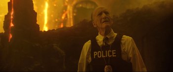 Movie still from “Bill & Ted Face the Music” (2020), directed by Dean Parisot – An old man in a police uniform looking up at a fire; Close Up shot, Over the shoulder angle