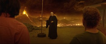 Movie still from “Bill & Ted Face the Music” (2020), directed by Dean Parisot – A man dressed as a monk standing in front of a burning landscape; Wide shot, High angle