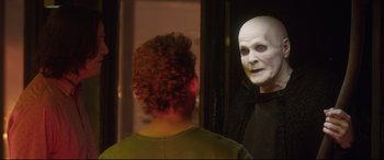 Movie still from “Bill & Ted Face the Music” (2020), directed by Dean Parisot – A man in a white mask looking at another man in a green shirt; Medium shot, Over the shoulder angle