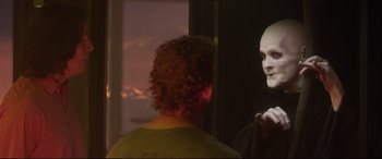 Movie still from “Bill & Ted Face the Music” (2020), directed by Dean Parisot – A person with a mask looking into a mirror; Medium shot, Over the shoulder angle
