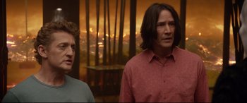Movie still from “Bill & Ted Face the Music” (2020), directed by Dean Parisot – Two men standing next to each other in front of trees; Medium shot, Over the shoulder angle