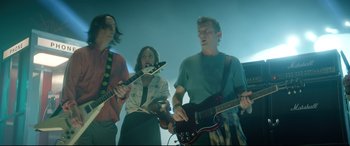 Movie still from “Bill & Ted Face the Music” (2020), directed by Dean Parisot – A group of young people playing instruments in a room; Medium shot, Low angle