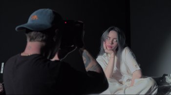 Movie still from “Billie Eilish: The World's a Little Blurry” (2021), directed by R.J. Cutler – A man taking a picture of a woman in a mirror; Close Up shot, High angle