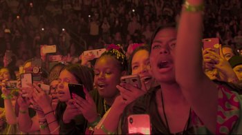 Movie still from “Billie Eilish: The World's a Little Blurry” (2021), directed by R.J. Cutler – A group of young people holding cellphones in their hands at an event; Medium shot, High angle