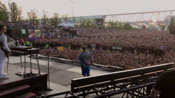 Movie still from “Billie Eilish: The World's a Little Blurry” (2021), directed by R.J. Cutler – A crowd of people at an outdoor concert; Extreme Wide shot, High angle