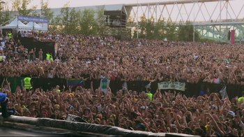 Movie still from “Billie Eilish: The World's a Little Blurry” (2021), directed by R.J. Cutler – A large crowd of people at an outdoor concert; Extreme Wide shot, High angle