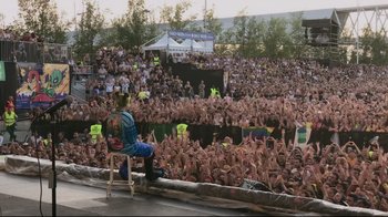 Movie still from “Billie Eilish: The World's a Little Blurry” (2021), directed by R.J. Cutler – A crowd of people at an outdoor concert; Extreme Wide shot, High angle