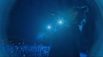Movie still from “Billie Eilish: The World's a Little Blurry” (2021), directed by R.J. Cutler – A person with a microphone in front of an audience; Medium shot, Low angle