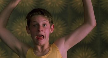 Movie still from “Billy Elliot” (2000), directed by Stephen Daldry – A young boy with his mouth wide open and his arms stretched out; Close Up shot, Low angle