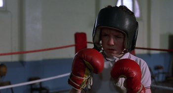 Movie still from “Billy Elliot” (2000), directed by Stephen Daldry – A young boy wearing boxing gloves in a boxing ring; Close Up shot, Low angle