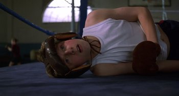 Movie still from “Billy Elliot” (2000), directed by Stephen Daldry – A young man laying on the ground wearing a baseball helmet; Medium shot, Overhead angle