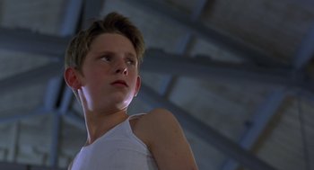 Movie still from “Billy Elliot” (2000), directed by Stephen Daldry – A young boy in a white tank top looking up; Close Up shot, Low angle