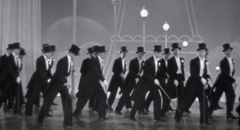 Movie still from “Billy Elliot” (2000), directed by Stephen Daldry – A group of men in top hats and suits walking; Wide shot, High angle