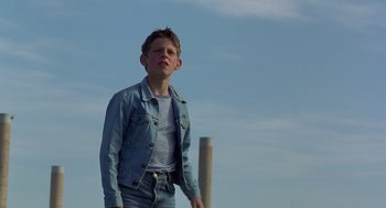 Movie still from “Billy Elliot” (2000), directed by Stephen Daldry – A young boy standing in front of a pole; Medium shot, Low angle