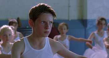 Movie still from “Billy Elliot” (2000), directed by Stephen Daldry – Two young boys in white tank tops are in a gymnasium; Close Up shot, Low angle