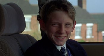 Movie still from “Billy Elliot” (2000), directed by Stephen Daldry – A young man in a suit and tie sitting in the back of a car; Close Up shot, Low angle