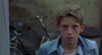 Movie still from “Billy Elliot” (2000), directed by Stephen Daldry – A young boy standing in front of a bicycle; Close Up shot, Over the shoulder angle