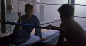 Movie still from “Billy Elliot” (2000), directed by Stephen Daldry – A woman in a blue robe is in a boxing ring; Medium shot, Over the shoulder angle