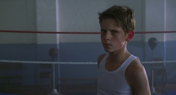 Movie still from “Billy Elliot” (2000), directed by Stephen Daldry – A young boy in a boxing ring wearing a white shirt; Close Up shot, Low angle