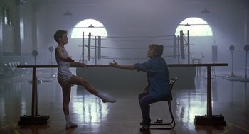 Movie still from “Billy Elliot” (2000), directed by Stephen Daldry – A woman sitting on a chair in front of a girl; Wide shot, Over the shoulder angle