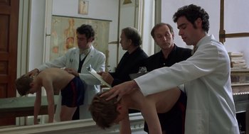 Movie still from “Billy Elliot” (2000), directed by Stephen Daldry – A group of men standing in front of a bathroom mirror; Medium shot, Low angle