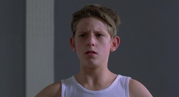 Movie still from “Billy Elliot” (2000), directed by Stephen Daldry – A young boy in a white shirt looking at the camera; Close Up shot, Low angle