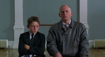 Movie still from “Billy Elliot” (2000), directed by Stephen Daldry – A man and a young boy in suits and ties; Medium shot, Low angle
