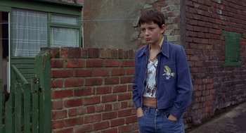 Movie still from “Billy Elliot” (2000), directed by Stephen Daldry – A woman standing in front of a brick wall; Medium shot, Over the shoulder angle