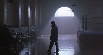 Movie still from “Billy Elliot” (2000), directed by Stephen Daldry – A person is walking in the dark in a building; Wide shot, Low angle