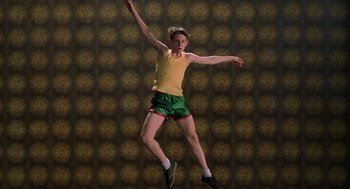 Movie still from “Billy Elliot” (2000), directed by Stephen Daldry – A man jumping in the air with his arms outstretched; Medium shot, Low angle