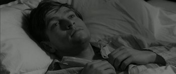 Movie still from “Billy Liar” (1963), directed by John Schlesinger – A man laying in a bed with his eyes closed; Close Up shot, High angle