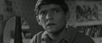 Movie still from “Billy Liar” (1963), directed by John Schlesinger – A black - and - white photo of a man looking at the camera; Close Up shot, High angle