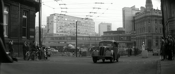 Movie still from “Billy Liar” (1963), directed by John Schlesinger – An old car parked on the side of the street; Extreme Wide shot, Low angle
