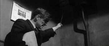Movie still from “Billy Liar” (1963), directed by John Schlesinger – A black and white photo of a man holding a sword; Medium shot, Low angle