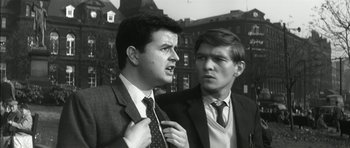 Movie still from “Billy Liar” (1963), directed by John Schlesinger – Two men in suits and ties standing next to each other; Close Up shot, Low angle