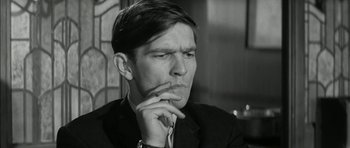 Movie still from “Billy Liar” (1963), directed by John Schlesinger – Black and white photograph of a man in a suit; Close Up shot, Low angle